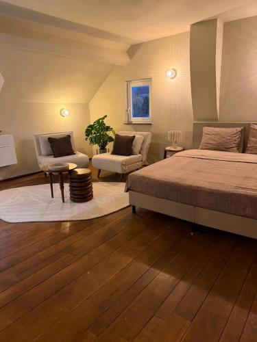 a bedroom with a bed and a couch and a chair at Bed and Breakfast 1691 in Valkenburg