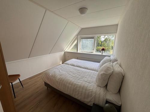 a bedroom with a bed in a room with a window at Bed & Boerderij 