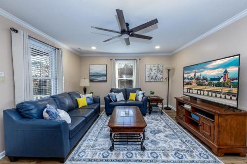 a living room with a blue couch and a flat screen tv at 3-Bedroom Home with King Bed, Smart TVs & Fenced Yard in New Bern