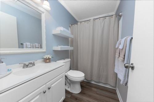 a white bathroom with a toilet and a sink at 3-Bedroom Home with King Bed, Smart TVs & Fenced Yard in New Bern