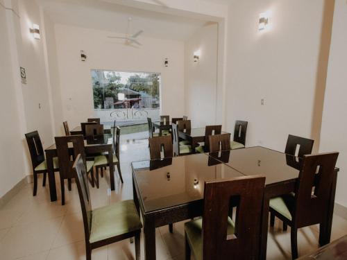 Un comedor con mesas y sillas de madera. en Tariri Hotel, en Pucallpa
