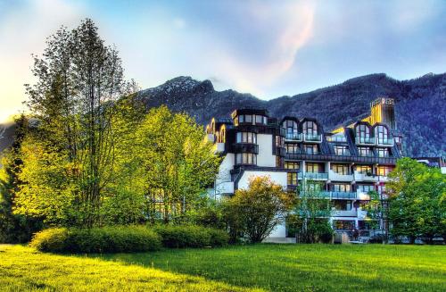 un gran edificio con montañas en el fondo en AMBER HOTEL Bavaria, en Bad Reichenhall