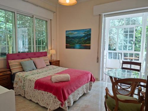 une chambre avec un lit, une table et des fenêtres dans l'établissement Oasis Ponte San Lázaro, à Saint-Jacques-de-Compostelle