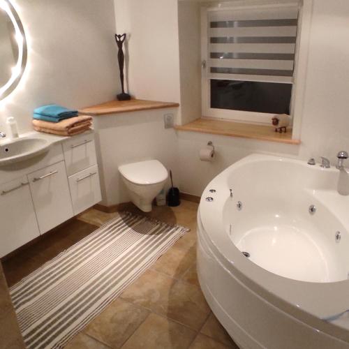 a bathroom with a tub and a toilet and a sink at Emily's Garden in Lintrup
