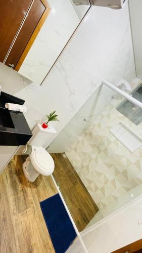a bathroom with a toilet and a blue rug at Studio moderno com piscina 350m do mar in Piçarras