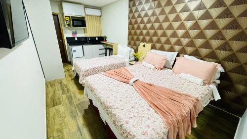 Ένα ή περισσότερα κρεβάτια σε δωμάτιο στο Studio moderno com piscina 350m do mar