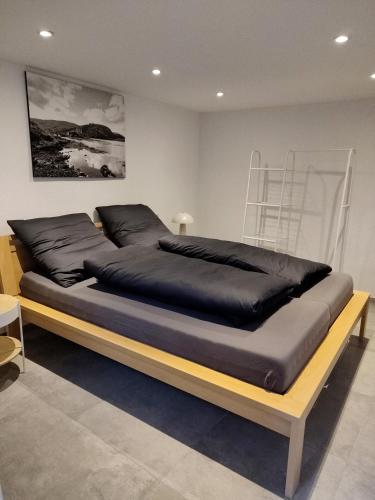 a bedroom with a large bed with black sheets at Südeifel Spangdahlem in Spangdahlem