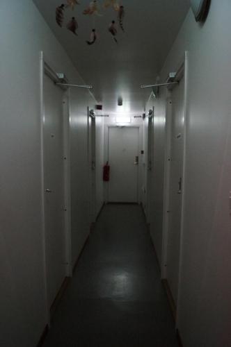 キルナにあるLaplanders roomsの白いドアと天井の照明のある廊下