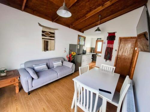 a living room with a couch and a table at Cabañas Ruben Dario 1 in Puerto Natales