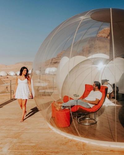 a woman walking next to a man in a bubble chair at Desert rose in Al Jafr