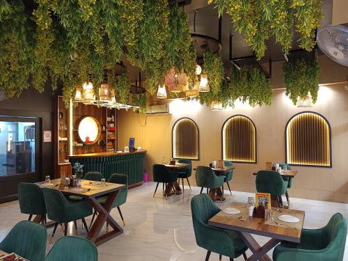 a restaurant with tables and chairs and plants at Hotel Bodhi Heritage And Restaurant in Gaya