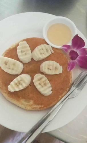 a pancake with bananas and syrup on a plate at Khaosok Foresta Resort in Phanom