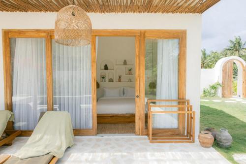 a room with a bed and a glass door at Turtle Villa 2 in Kuta Lombok