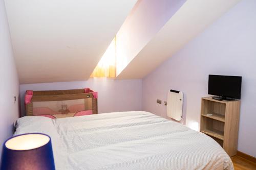 a small bedroom with a bed and a tv at Asturica in Astorga