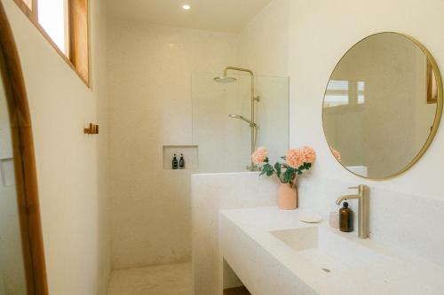 a white bathroom with a sink and a mirror at Turtle Villa 2 in Kuta Lombok