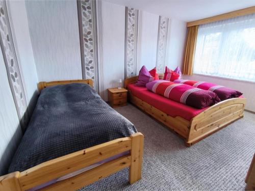 a bedroom with a bed and a red couch at Am Springelbach in Hinternah