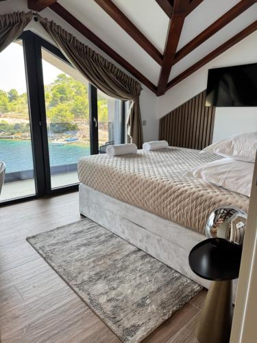 een slaapkamer met een bed en uitzicht op het water bij Villa Venetta beach house ,Island Žirje, Šibenik in Muna