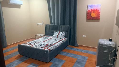 a bedroom with a bed and a painting on the wall at LOUNEL BnB in Kumasi