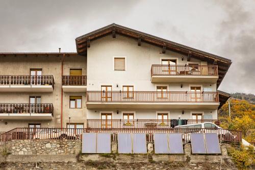 a large white building with a car parked in front of it at Mon grenier in Aosta