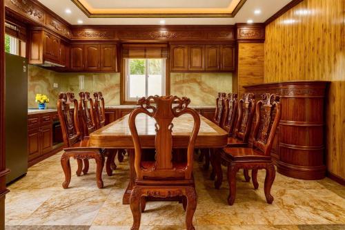 ein Esszimmer mit einem Holztisch und Stühlen in der Unterkunft Luxurious River Castle 7 bedrooms in Ho-Chi-Minh-Stadt