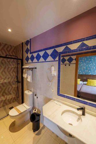 a bathroom with a sink and a toilet and a mirror at Hotel Sol in Toledo
