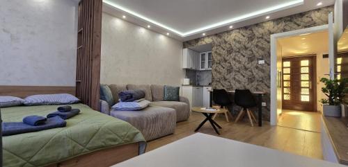 una sala de estar con dos camas y un sofá en Leaf & Loft, en Novi Sad