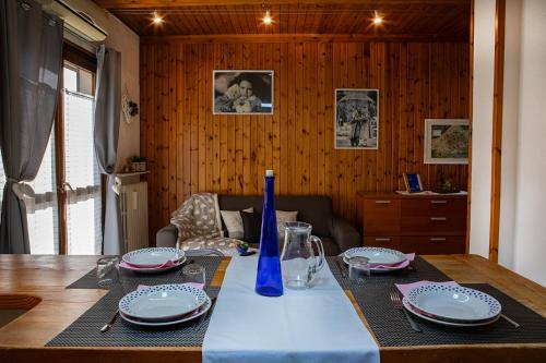 a table with plates and a blue vase on it at Mon grenier in Aosta