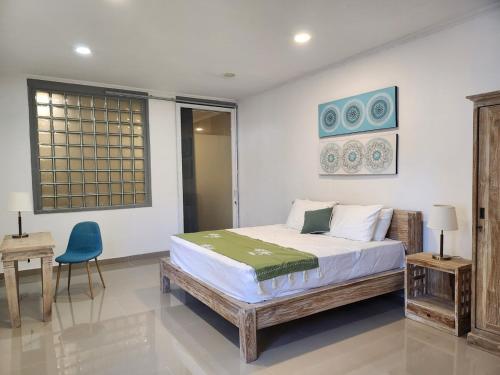 a bedroom with a bed and a blue chair at Bendesa Villa 14 in Ungasan