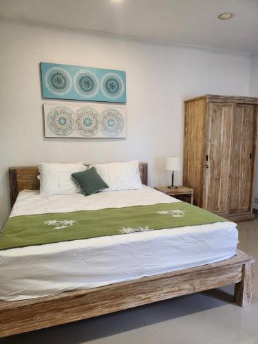 a bedroom with a large bed with a green blanket at Bendesa Villa 14 in Ungasan