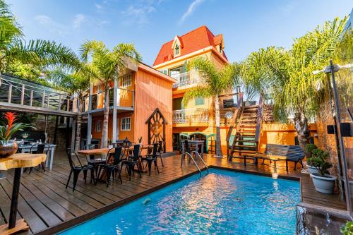 an outdoor patio with a pool and a house at F&F alojamiento in Punta del Este