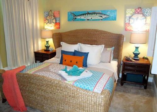 a bedroom with a bed with a wicker couch at Beachview Condo at Beau View - 303 - fully furnished 3 bedroom 3 bathroom in De Buys