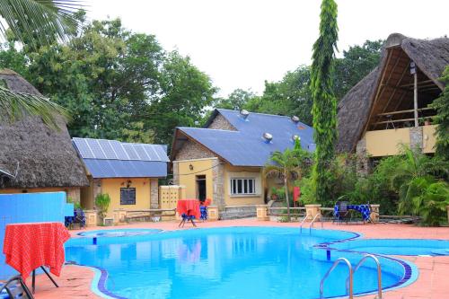 a large swimming pool in front of a house at Arra Fishing Lodge in Adjumani
