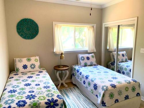 a bedroom with two beds and two windows at 148 Beau Clair - Beachside Townhome with Pool in Long Beach in Long Beach