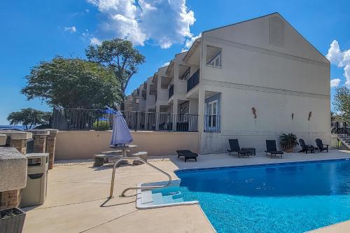 a building with a swimming pool in front of a building at 146 Beau Clair - Beachside Townhome with Pool in Long Beach in Long Beach