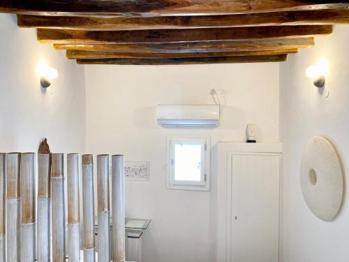 a kitchen with white walls and wooden ceilings at Cyclops House in Serifos Chora