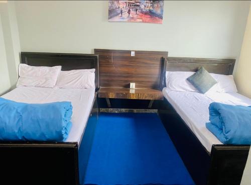 two beds sitting next to each other in a room at Hotel MAQ Lumbini in Lumbini