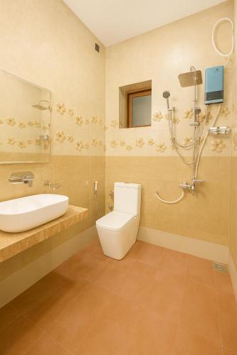 a bathroom with a toilet and a sink and a shower at ACCOM Premium Residence in Gangodawila