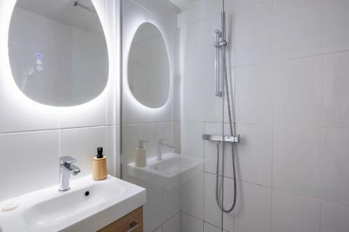 a white bathroom with a sink and a shower at Studio Exotique Hyper-Centre Enghien 12min Paris in Enghien-les-Bains