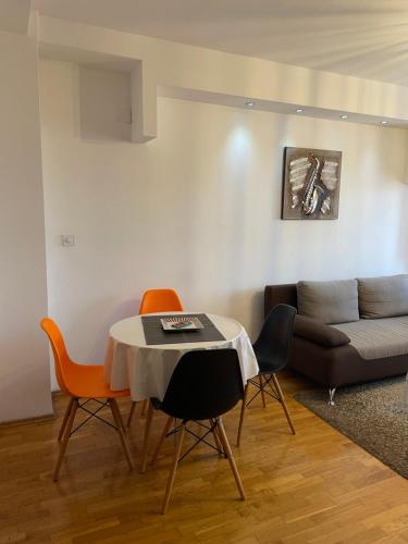 un soggiorno con tavolo, sedie e divano di City Center Gem a Skopje