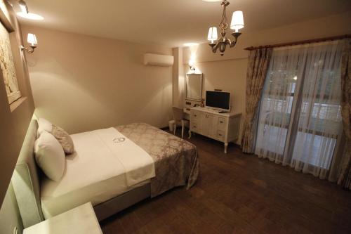 a hotel room with a bed and a television at Livia Hotel Ephesus in Selcuk