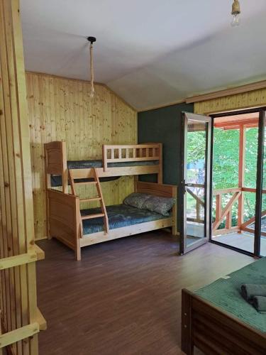 a bedroom with two bunk beds and a sliding glass door at Villa Maxi Likani in Borjomi