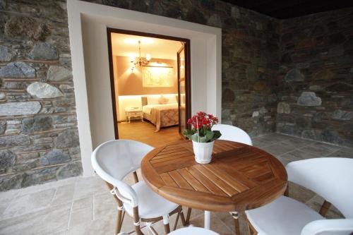 a dining room with a wooden table and white chairs at Livia Hotel Ephesus in Selcuk