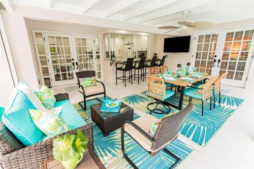 a living room with a table and chairs at Oleander Drive - Coquina Sands in Naples