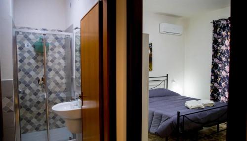 a bathroom with a bed and a sink and a shower at Residence Prato in Trapani