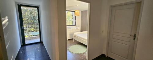 a hallway with a bathroom with a door and a window at Villa Lucitello by Monarca Location, refuge Familial à 10 minutes de Saint Florent in Barbaggio