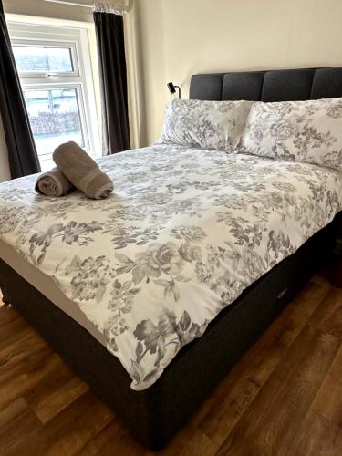 a bed with a blanket and a pillow on it at Ivy Cottage in Swansea