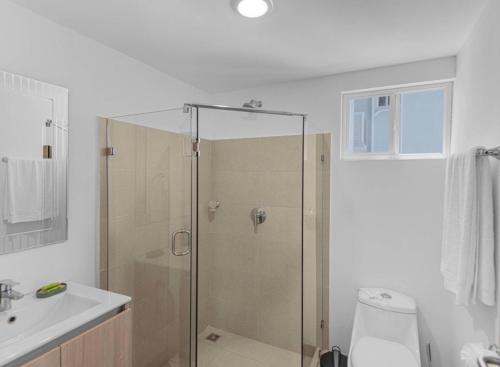 a bathroom with a shower with a toilet and a sink at Jacó Pacífico in Jacó