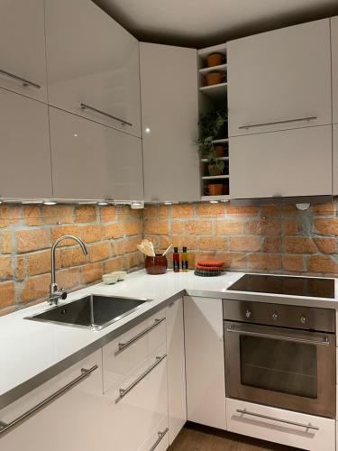 a kitchen with white cabinets and a sink at Apartment Aker brygge- Oslo sentrum in Oslo