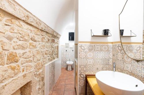 ein Badezimmer mit einem Waschbecken und einer Steinmauer in der Unterkunft Civico 11 in Molfetta