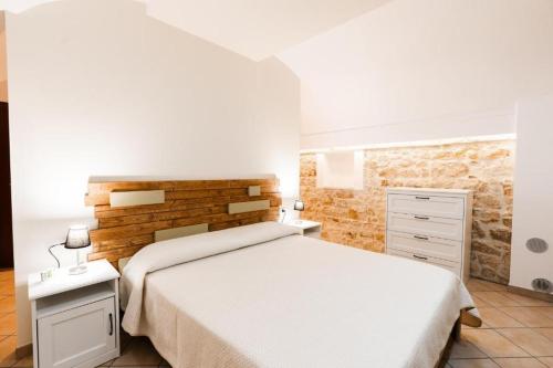ein Schlafzimmer mit einem weißen Bett und einer Ziegelwand in der Unterkunft Civico 11 in Molfetta